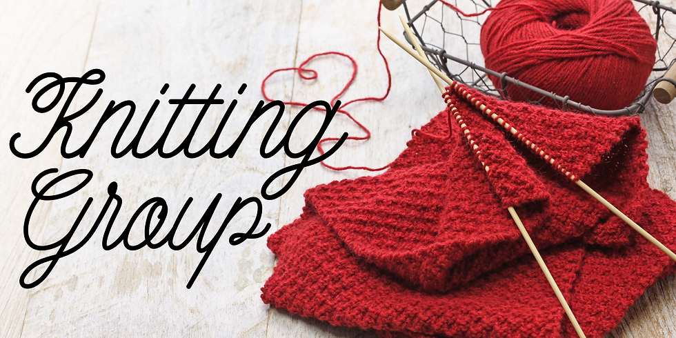 Deep red wool on a ball and two needles with what looks like a parially completed top. Resting on a light, wooden table top with the words Knitting Group in script.