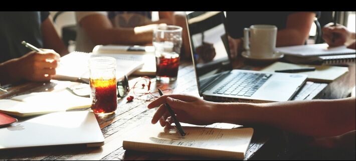 View of writing books showings hands and pens