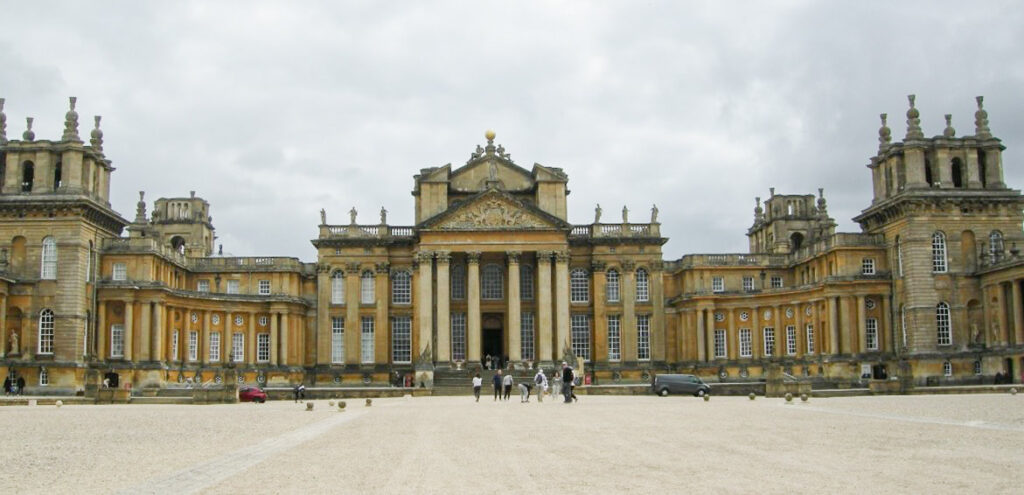 Large palace with columned entrance and statues on front of the roof