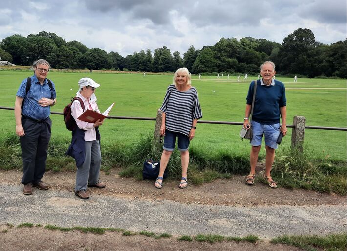Four walkers posing beside Tunbridge Wells cricket pitch on the Common.
