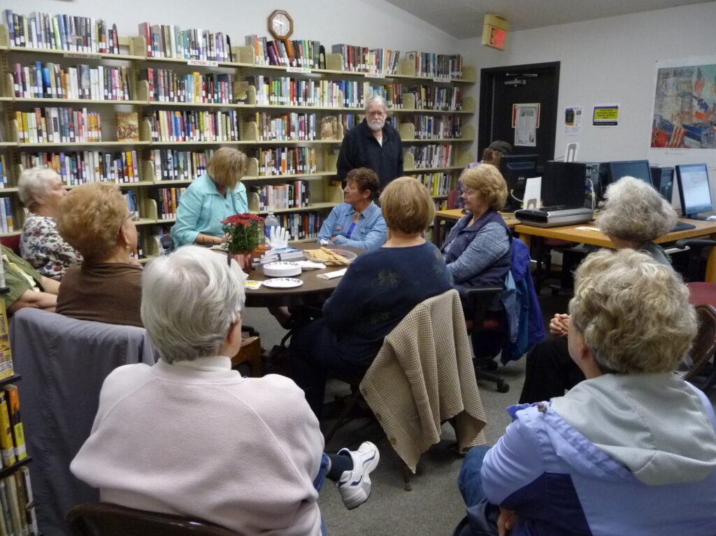 Elderly eople sitting in a library discussing books