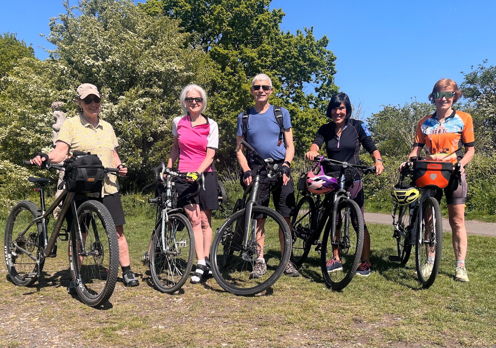 Five cyclists standing by bikes